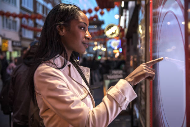 istock Woman using a touch screen finding informations online in London city streets 925239584