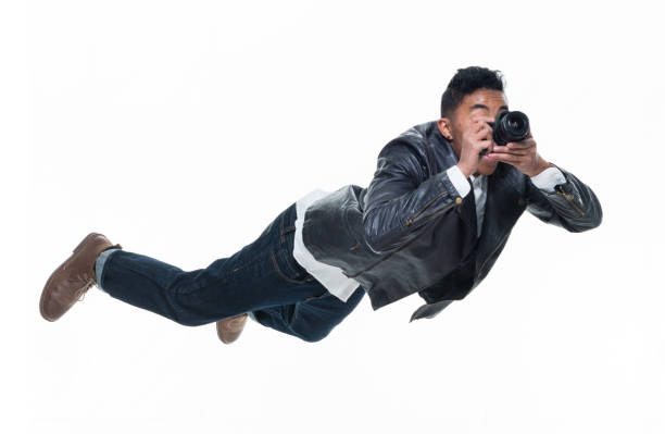 istock Daring young handsome male in mid air falling and using a camera 925239594
