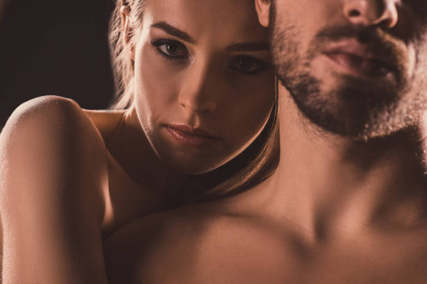 istock sensual lovers embracing and looking at camera, on brown 925240480