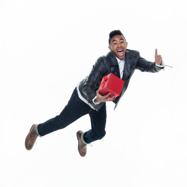 istock Daring young handsome male in mid air falling and holding a gift box 925240522