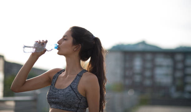 istock Tired sporty woman drinking water 925241144
