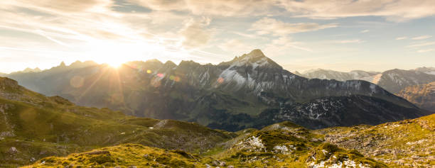 impresionante amanecer en las montañas. buen lente llamaradas y rayos de sol - sunbeam cloud panoramic sky fotografías e imágenes de stock