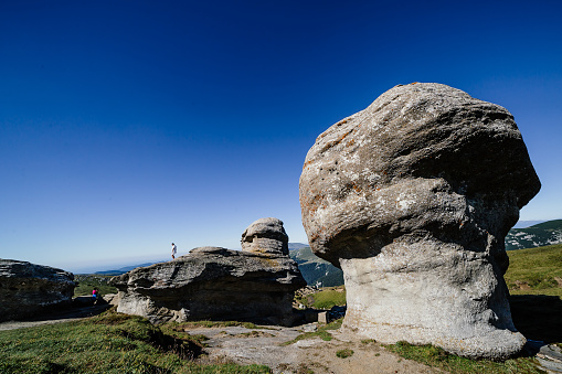 BUSTENI, ROMANIA - AUGUST 2, 2017: Tourists visit monumental rocks in Bucegi natural park, Busteni, Transylvania, Romania.
