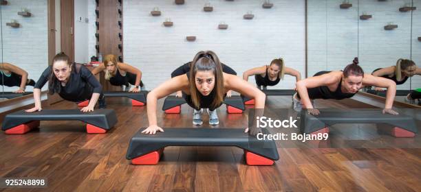 Group Of Fitness Women Doing Push Ups On Aerobic Stepper In Gym Stock Photo - Download Image Now