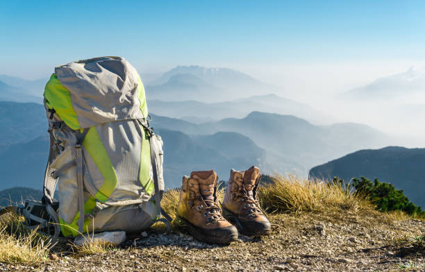 Hiking equipment. Backpack and boots on top of mountain. stock photo