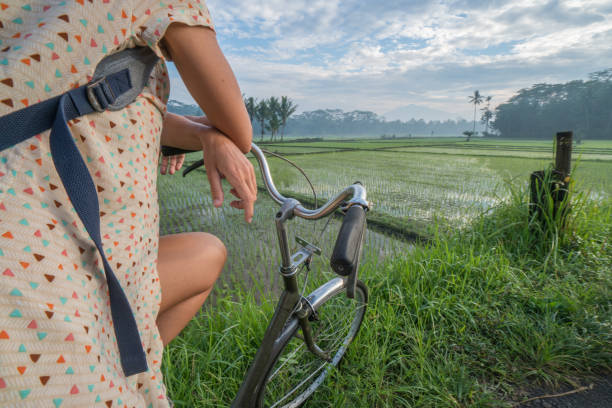 istock Woman on bicycle stops to admire rice fields, Indonesia 925252692