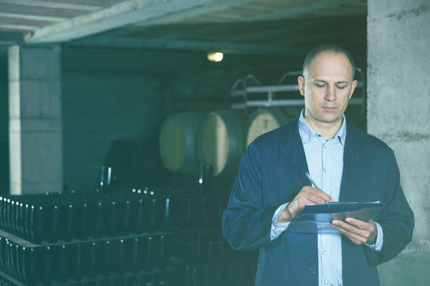 istock Wine producer with clipboard in wine cellar 925254850