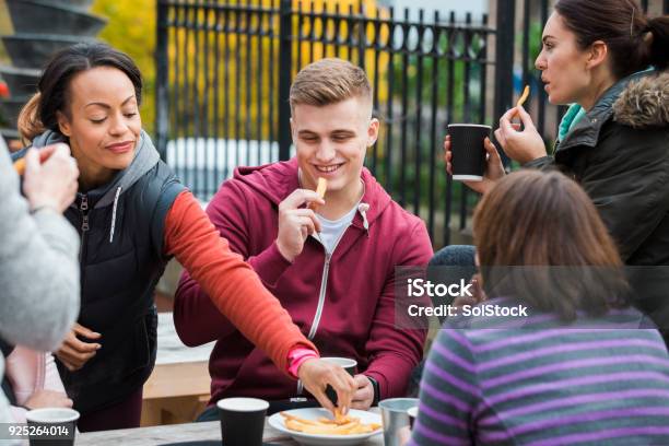 A Group Of Friend Eating Chips Stock Photo - Download Image Now - Adult, Adults Only, Bonding