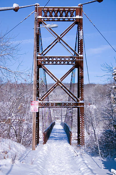 Enferrujado ponte suspensa de pedestres no inverno - foto de acervo