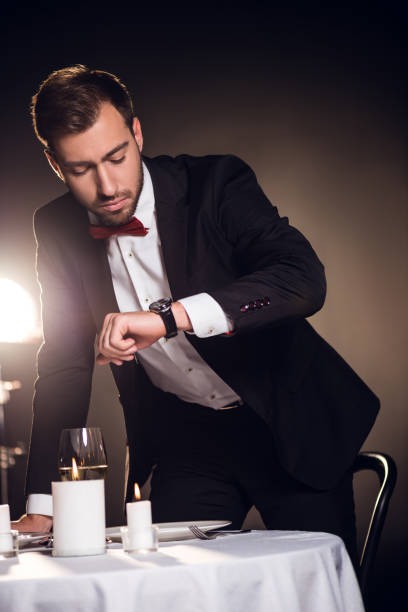 istock handsome man in jacket looking at watch and waiting for romantic date in restaurant 925267266