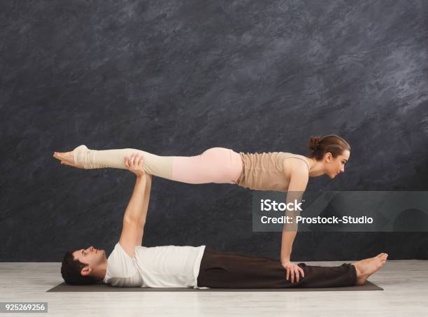 Young Couple Practicing Acroyoga On Mat Together Stock Photo - Download Image Now - Acroyoga, Acrobatic Activity, Active Lifestyle