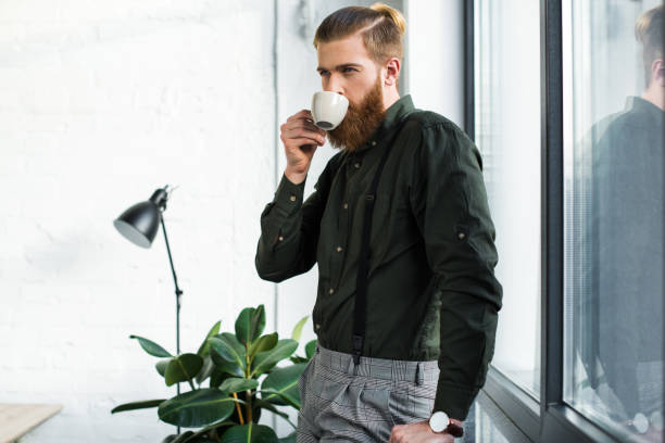 istock handsome businessman drinking coffee in office 925272286