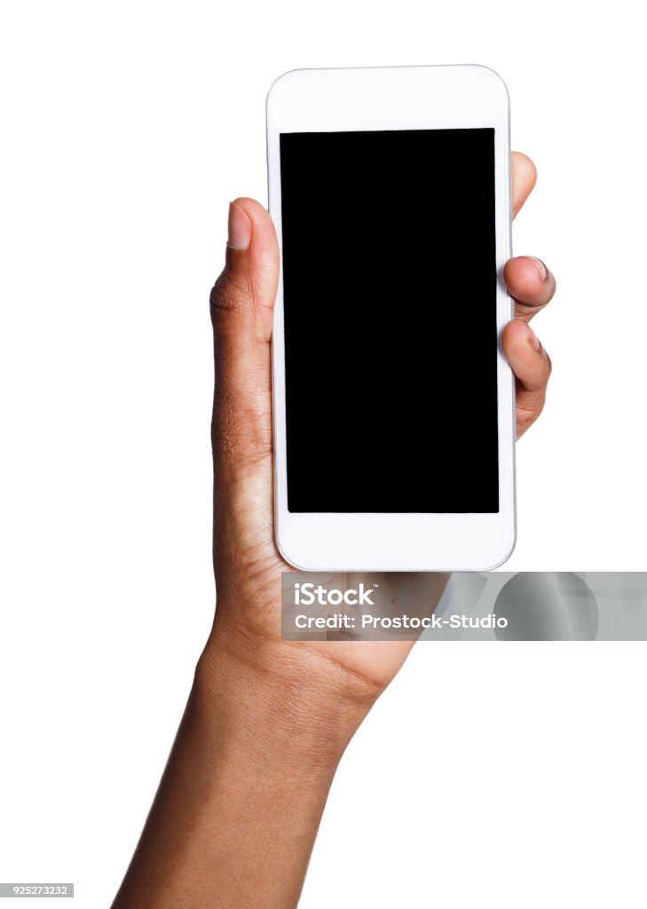 Black hand holding mobile smart phone with blank screen African-american female hand holding mobile smart phone with blank screen, isolated on white background. Copy space for advertisement of mobile app, mockup Telephone Stock Photo