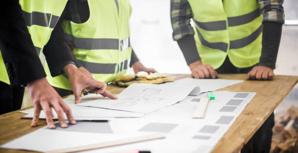 istock Male and female plumber going through construction plan 925273546