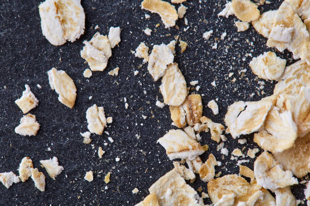 istock Yellow oats pyramid positioned in the corner on a black stone background 925276268