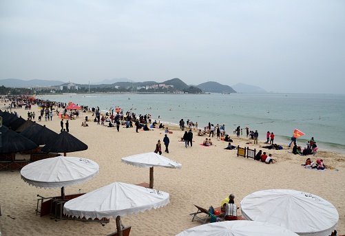 Crowd of local tourists on Dadonghai beach, near Sanya city, Hainan, China. Sanya's beach culture originated at Dadonghai. There are loads of water sports on offer at the bay.