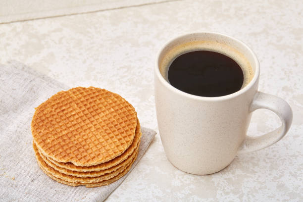 istock Close-up white cup of coffee with waffles on white background, top view 925280212