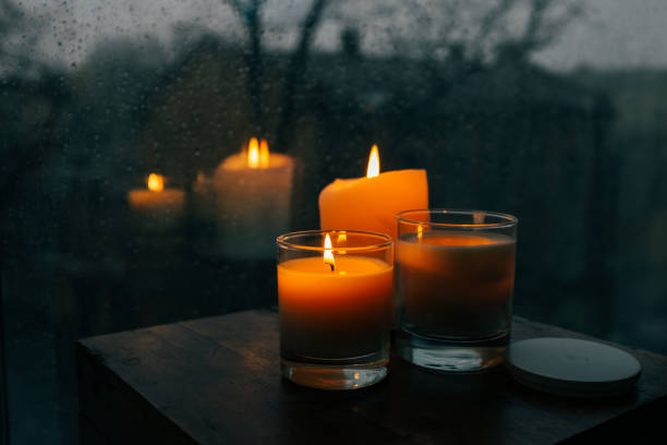 istock Three burning candles on table, cozy rainy day an home 925280874
