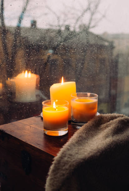 istock Three burning candles on table, cozy rainy day an home 925281018
