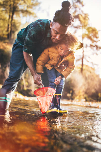 istock Father teaching son how to fish with fishing net 925283258