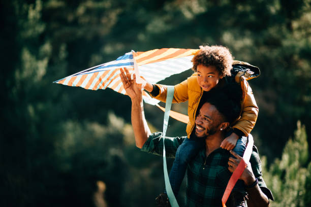 若い父親と息子が楽しんで自然の中にカイトを飛行 - 凧 ストックフォトと画像