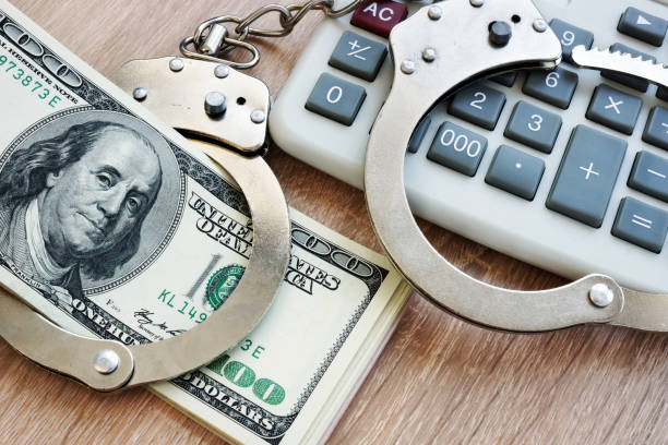 Audit fraud. Handcuffs and money. Economic crime concept. Audit fraud. Handcuffs and money. Economic crime concept. white collar crime handcuffs stock pictures, royalty-free photos & images