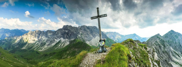 istock Wooden summit cross and summer colors in mountains. Panoramic view. 925287748