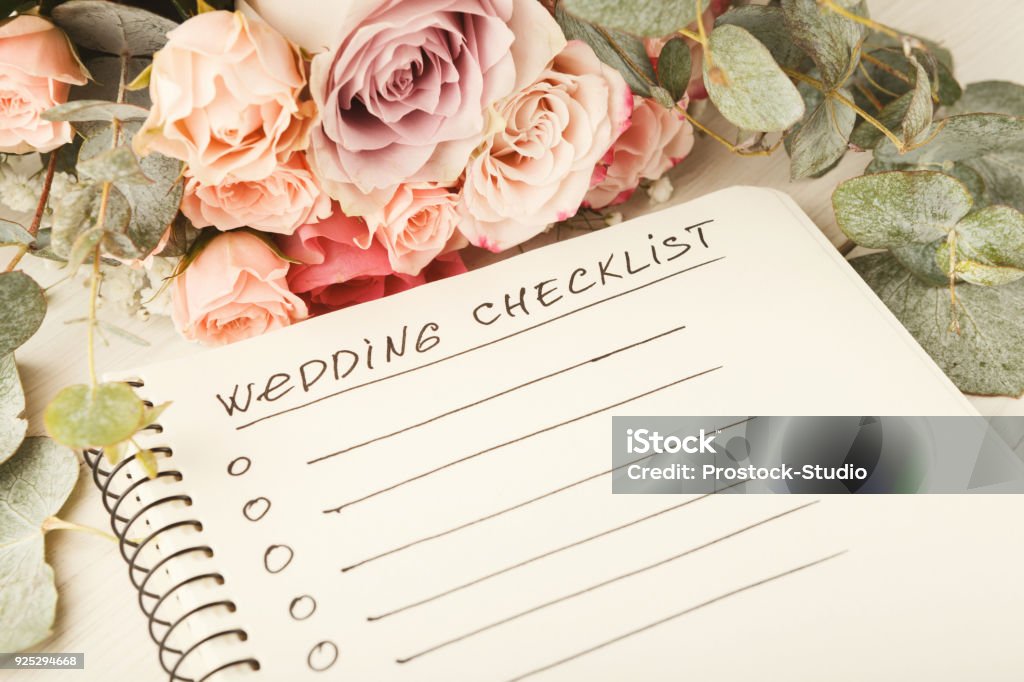 Wedding checklist and rose bouquet Wedding checklist with copy space and rose bouquet on the white desktop. Marriage planner concept, copy space. Wedding Stock Photo