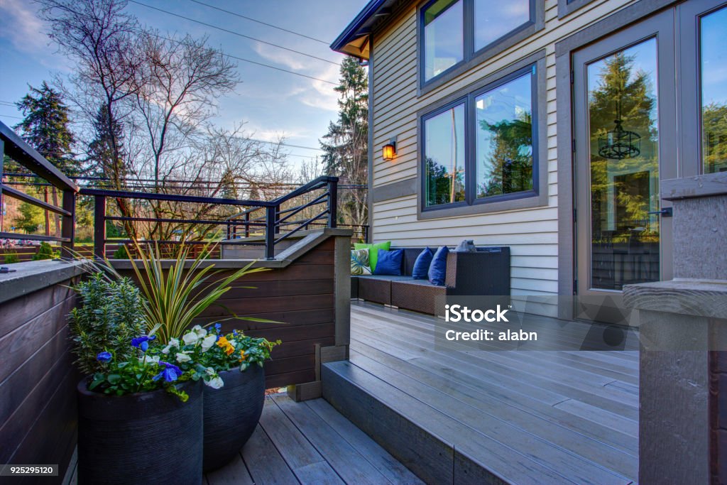 New construction home exterior boasts luxury deck New construction home exterior boasts luxury oversized deck overlooking a Well-designed garden. Customized Stock Photo