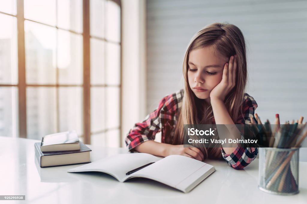 Little cute girl Little cute girl is bored and tired with doing her homework. Homework Stock Photo