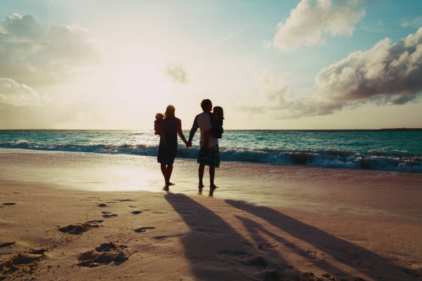 istock happy family with two kids walking at sunset beach 925300064