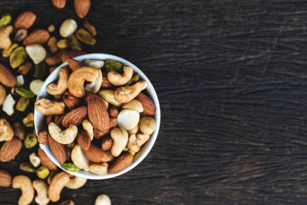 mezcla de frutos secos en bowl - nut fotografías e imágenes de stock