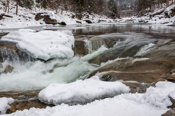 istock Winter landscape. Mountain river flows from the rocks. Snow and mountain river 925307354