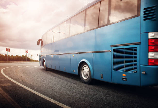 автобус движется по дороге в городе рано утром - rules of the road стоковые фото и изображения