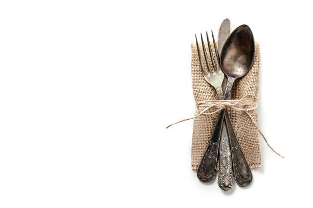 cubiertos antiguos en una arpillera aislado en blanco - silverware place setting napkin fork fotografías e imágenes de stock