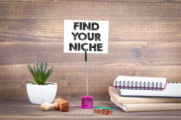 Photo of Find your niche. Wooden table with stationery