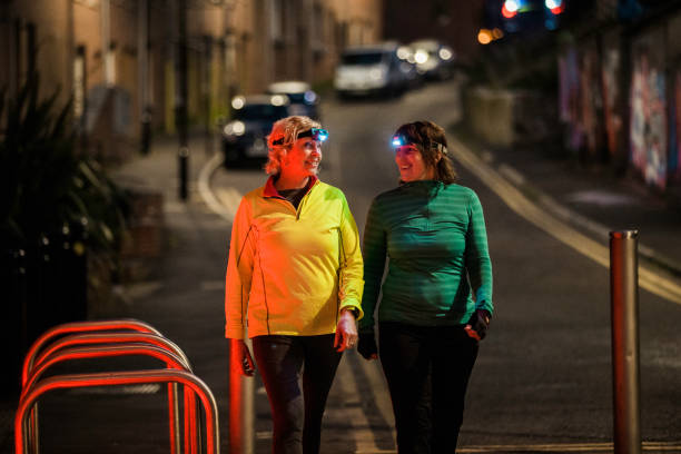 due amici che camminano insieme di notte - walking at night foto e immagini stock
