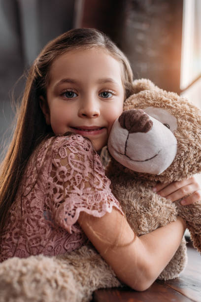 istock happy little child embracing teddy bear ond looking at camera 925316556