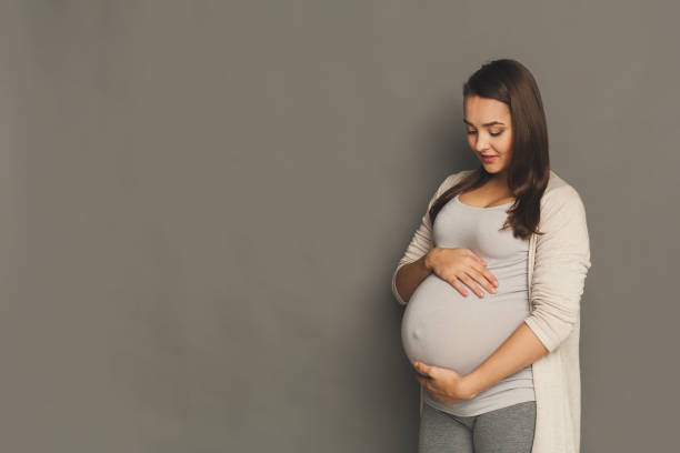 Pensive pregnant woman dreaming about child Pensive pregnant woman dreaming about child. Young happy expectant thinking about her baby and enjoying her future life. Motherhood, pregnancy, happiness concept, copy space abdomen photos stock pictures, royalty-free photos & images