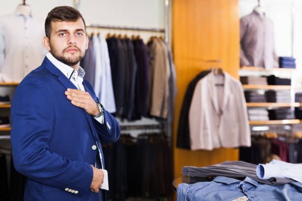 istock Man customer choosing jacket in men clothes store 925328036