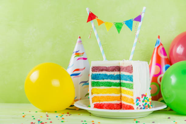 istock Birthday background - striped rainbow cake with white frosting 925328298