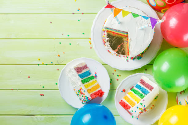 istock Birthday background - striped rainbow cake with white frosting 925328368