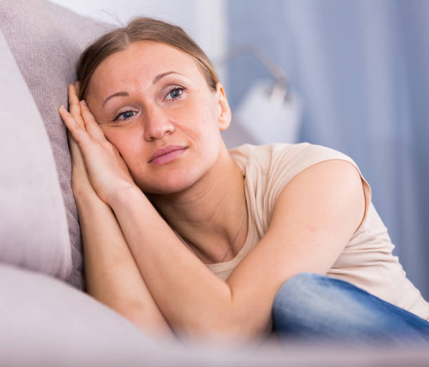 istock Sad woman sitting on sofa 925331538