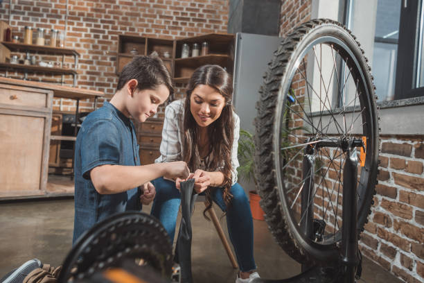 istock Mother and son fixing bicycle tire 925332024