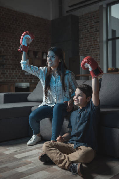 семья в боксерских перчатках смотреть матч - family television fighting watching стоковые фото и изображения