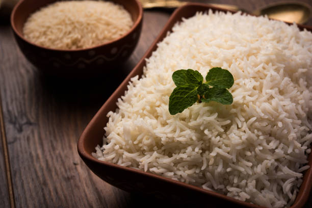 istock Cooked plain white basmati rice in terracotta bowl over plain or wooden background 925336398