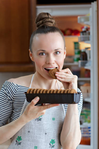 istock Young lady between 30 and 40 years old is trying some biscuits. 925340414