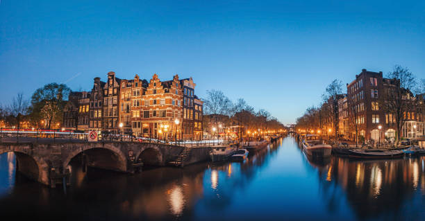 Amsterdam Canals by Night Amsterdam tranquil canal scene with canal houses, bicycles and bridge in the Jordaan neighborhood by night in Netherlands. Shot in long exposure on blue hours. canal house stock pictures, royalty-free photos & images