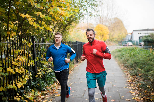 istock Two Male Friends Running Together 925344436