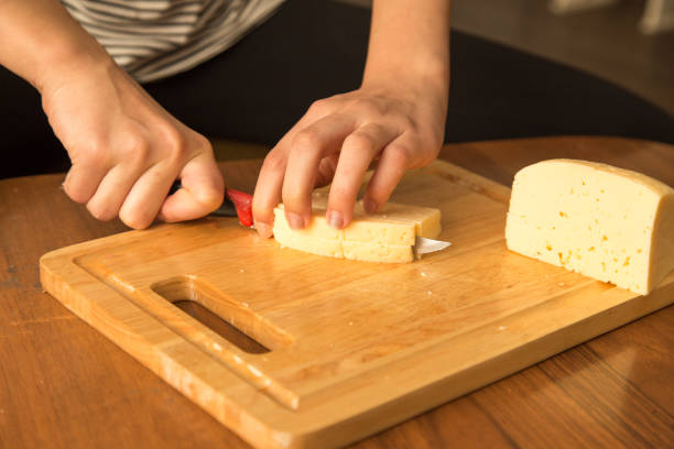 istock Slicing cheese with a knife on the board 925361828